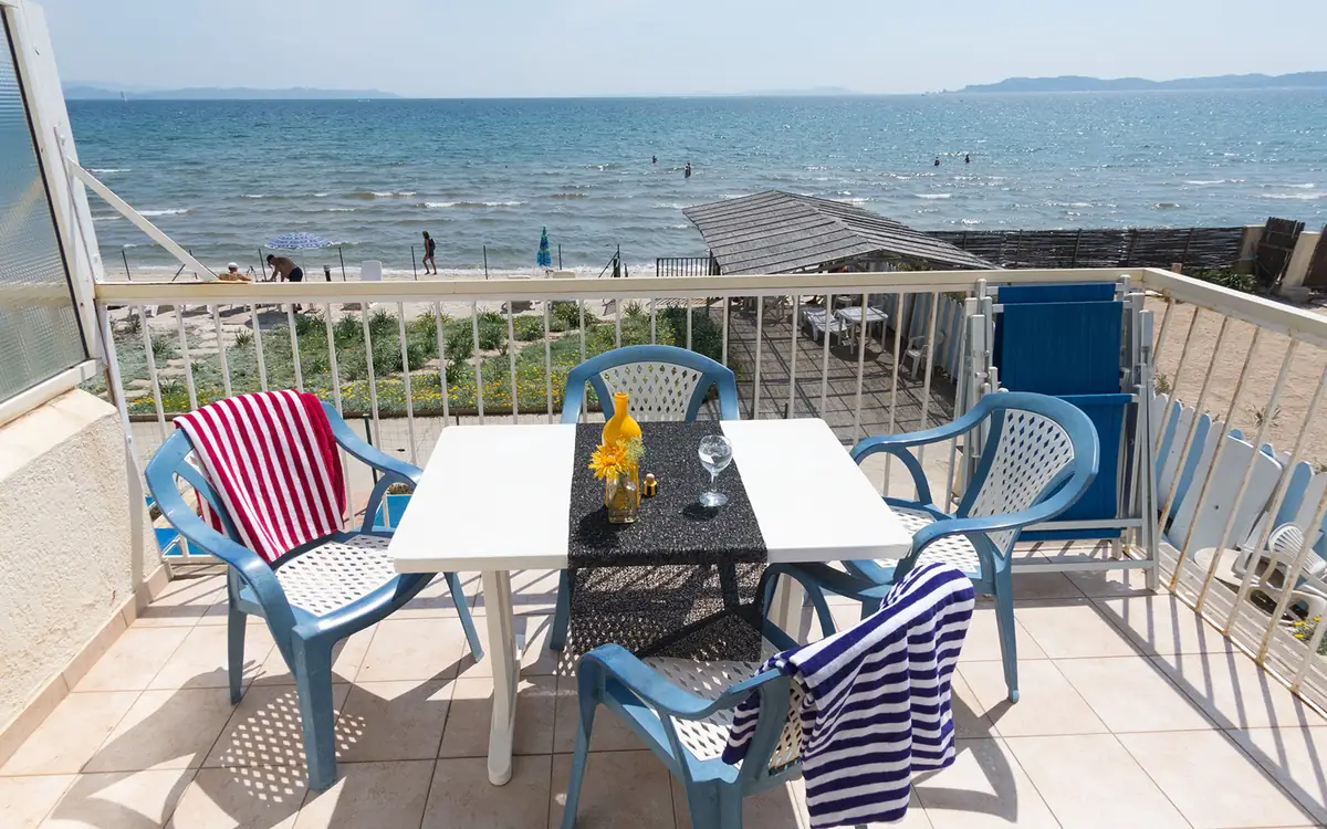 Table et fauteuils sur une terrasse avec vue sur la mer