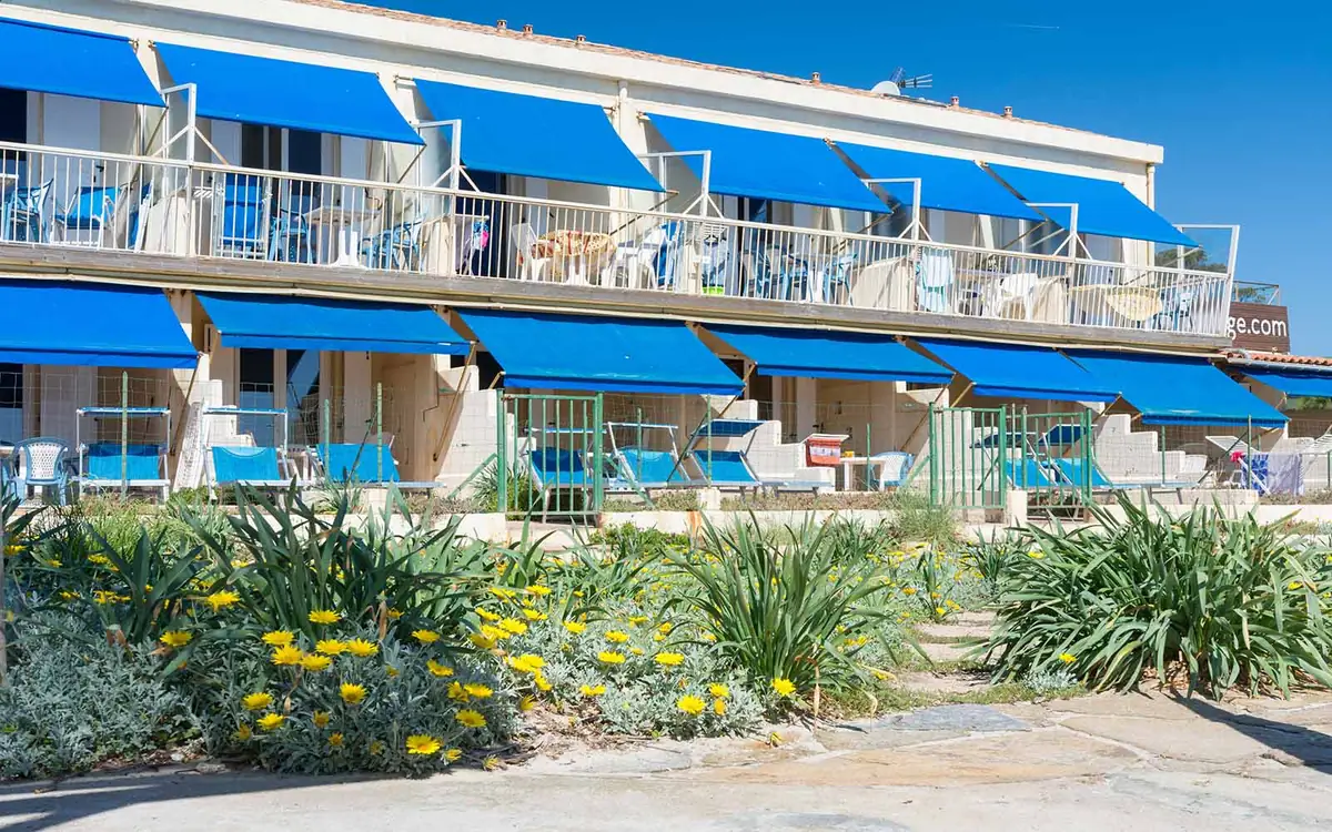Balcons de la résidence avec stores bleus et jardin fleuri